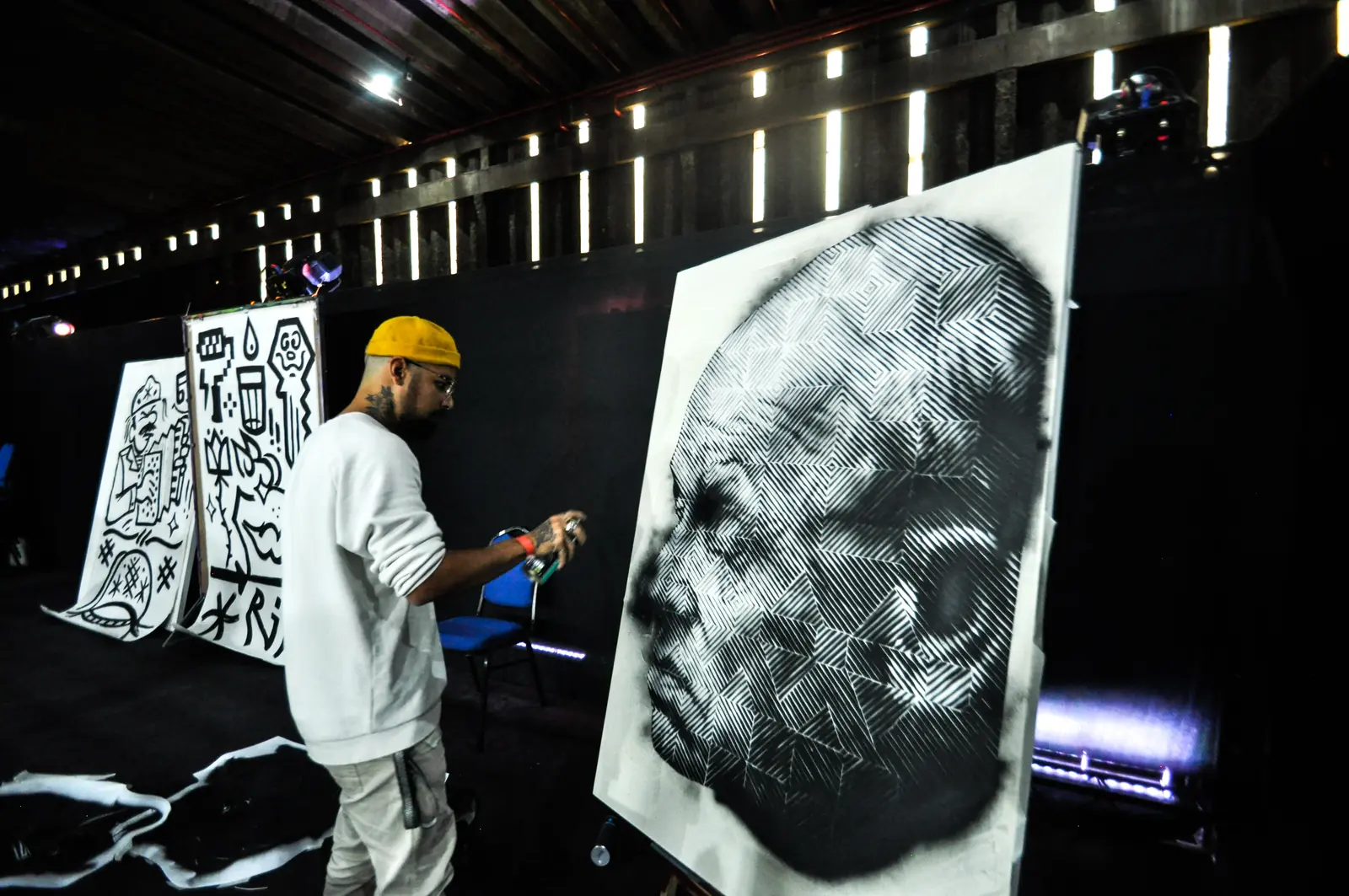 Artista pintando ao vivo um grande retrato em preto e branco no Pixel Show 2022
